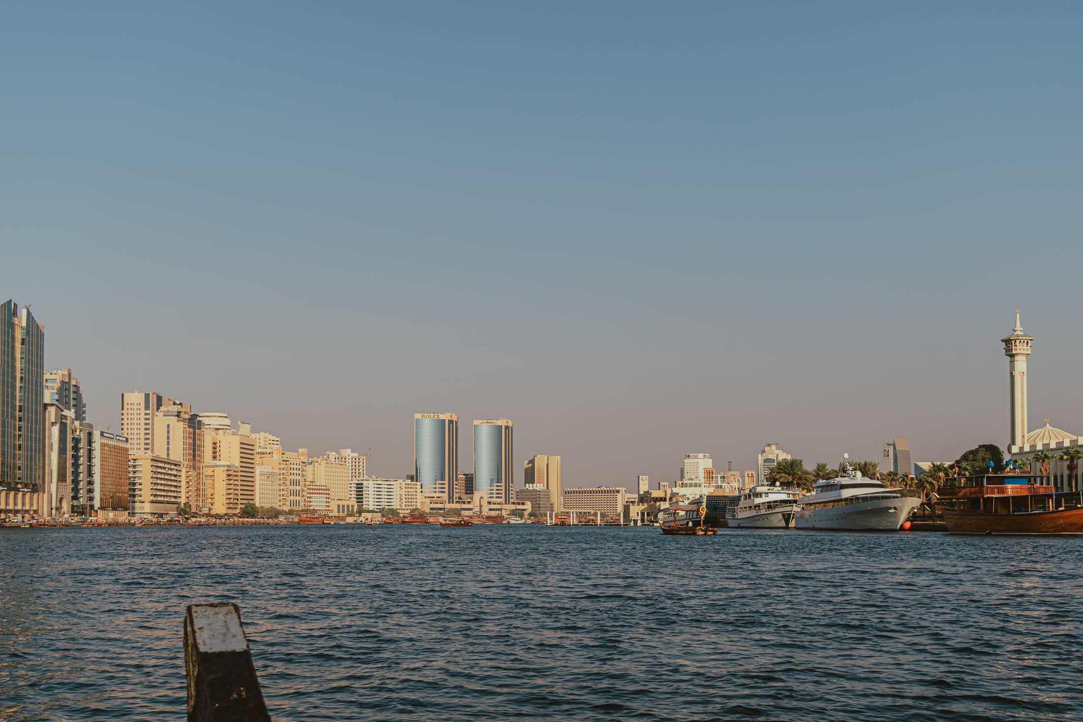 Traditional boats on Dubai Creek with the city skyline in the background